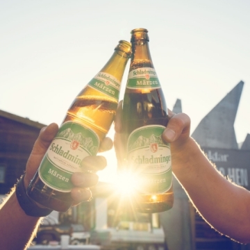 Zwei Bierflaschen werden gegen die Sonne gehalten